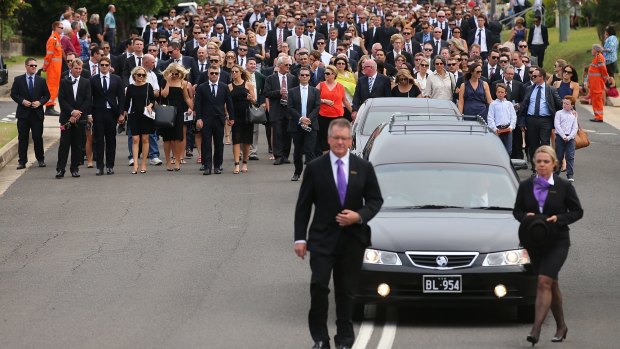 Procession: Mourners walk behind the hearse at Phillip Hughes' funeral in Macksville.