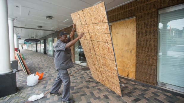Perry Williams puts up plywood shutters to cover the windows of the Diamonds International store, in preparation for the arrival of Hurricane Joaquin, in Nassau, Bahamas on Thursday.