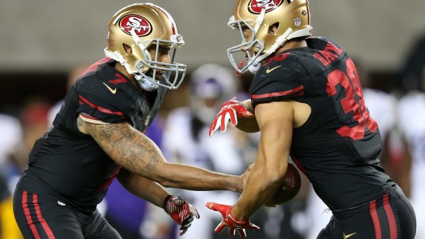 On the charge: Colin Kaepernick hands the ball off to Jarryd Hayne.