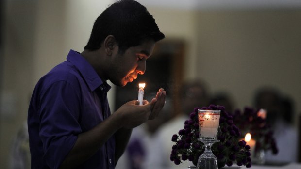 A Bangladeshi boy lights a candle for victims of the Dhaka cafe attack.