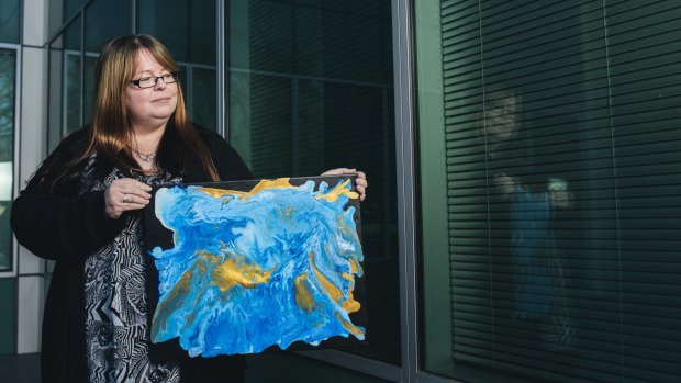 Kate McCormack with her painting Flow, which she is entering into the first Palliative Care Australia art competition.