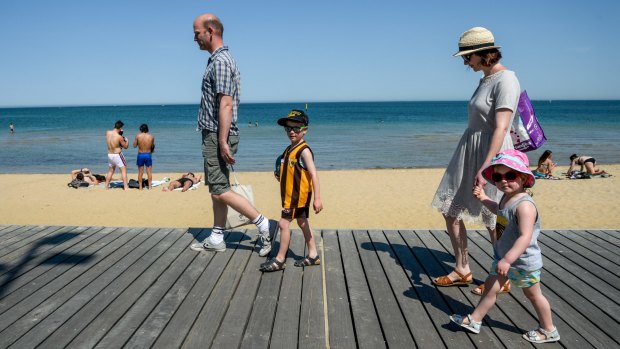 Young Hawthorn supporters Ben and Florence Page with their parents at St Kilda Beach.