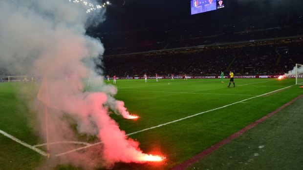 Flares burn on the pitch.