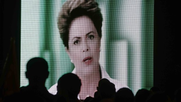 People watch a speech by Brazilian President Dilma Rousseff broadcast on the Workers Party's television program on Thursday evening.