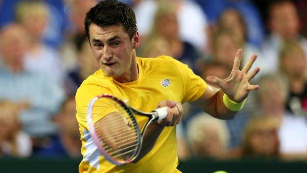 Under pressure: Bernard Tomic plays a forehand return to Britain's Andy Murray.