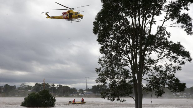 An elderly woman, isolated by floodwaters at Gillieston Heights, died after setting out to buy milk.