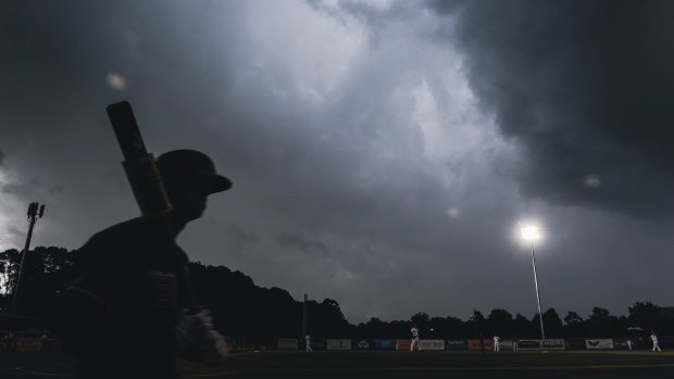 Hail arrives with a storm over Narrabundah during a baseball game.

