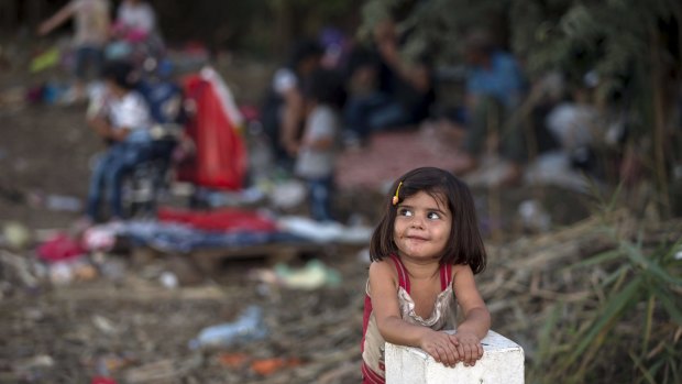 A Syrian migrant girl leans on a border stone on the Serbian border with Hungary near the village of Horgos.