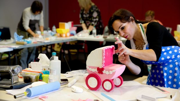 "I do anything": Verusca Walker shows a class how to decorate a traditional baby stroller cake.