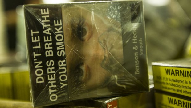 Australian plain packaging features prominent warnings and subdued brand names.