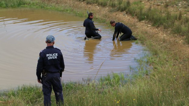 Police search a dam at the property. 