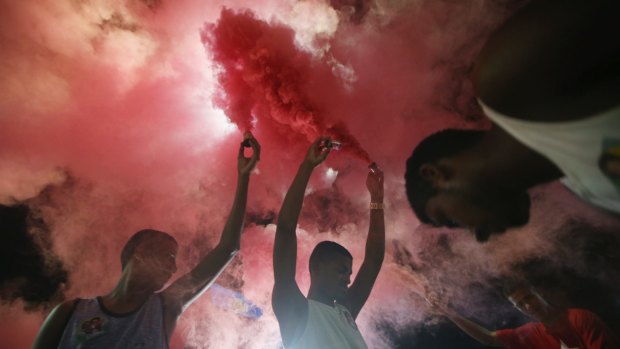 Anti-impeachment protesters light red smoke, the colour of the Workers' Party, in Rio de Janeiro.
