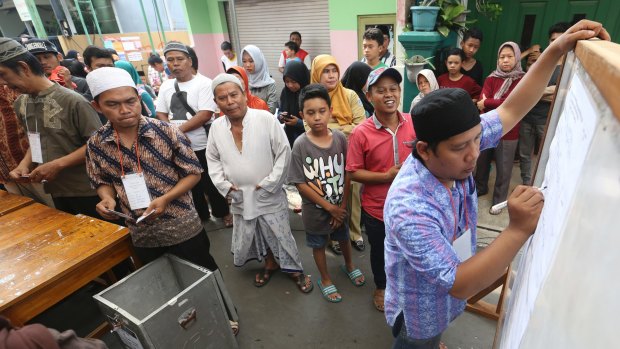 An electoral worker writes down votes during the runoff election in Jakarta.