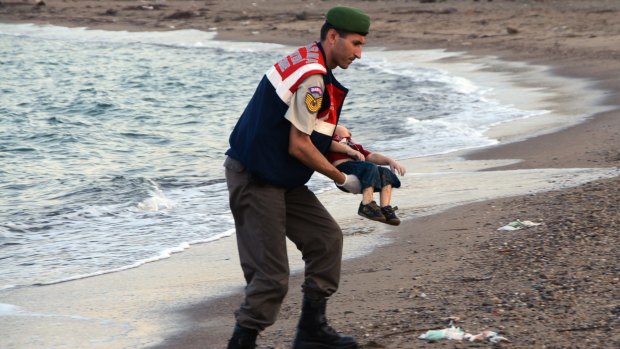 A paramilitary police officer carries the body of Aylan Kurdi after refugees died when boats capsized near the Turkish resort of Bodrum in September.