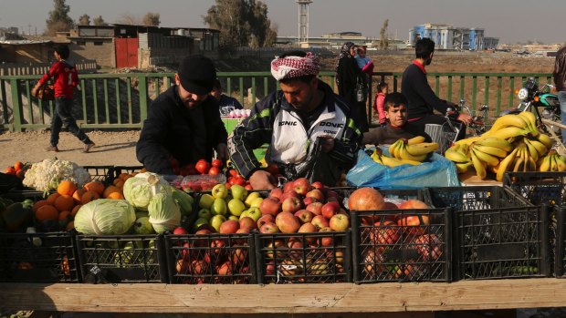 Civilians shop on the eastern side of Mosul on January 18, 2017 after Iraqi government troops announced on they were in 'full control' of eastern Mosul.