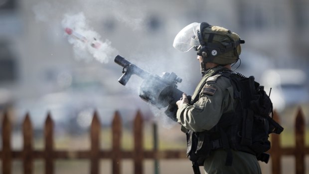 An Israeli soldier shoots tear gas in Ramallah. 