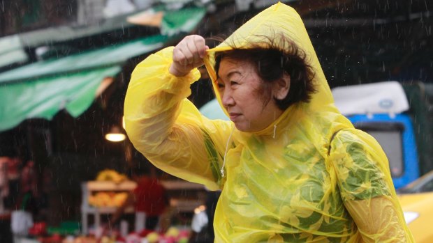 A woman struggles against powerful gusts of wind generated by Typhoon Megi.