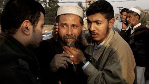 A man who lost a family member in the blast is comforted.