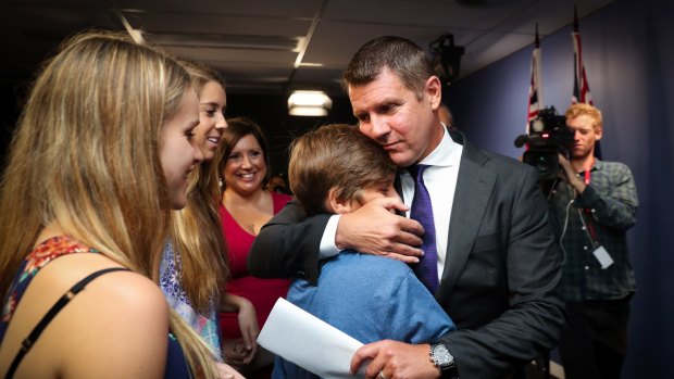 Premier Mike Baird embraces his family after the press conference announcing his resignation.