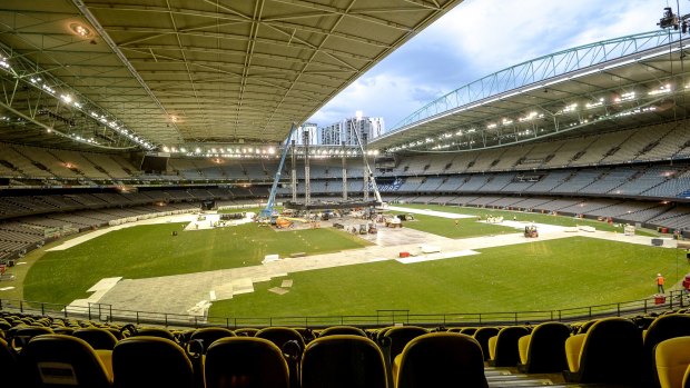 Workers at Melbourne's Etihad Stadium break down the stage after Adele's Sunday night concert. The ground will host a round-one AFL match on Saturday night.