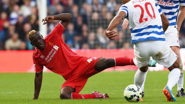 Not so super: Mario Balotelli competes with QPR's Karl Henry.
