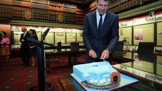 NSW Premier Mike Baird cuts a cake in the shape of NSW for his 47th birthday before a party room meeting of the NSW Liberals on Wednesday.