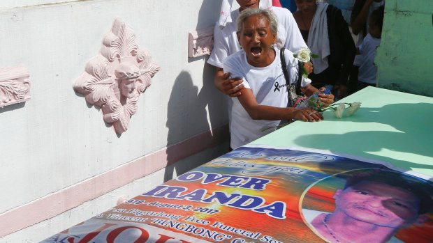 Elvira Miranda cries over the tomb of her son Leover, who was killed in what police said was a drug sting operation.