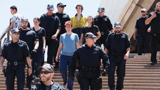 The arrested activists are escorted to police vehicles after being brought down from the Sydney Opera House sails.