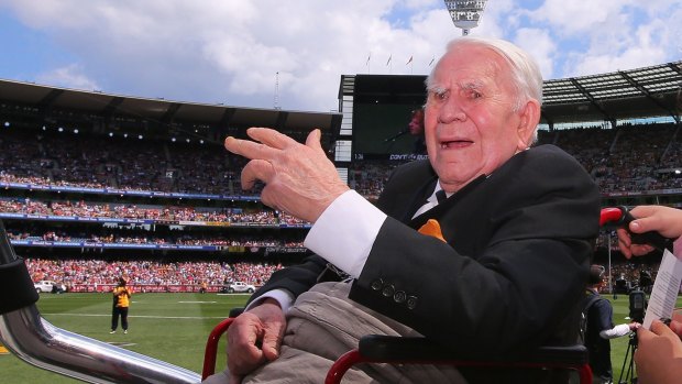 Magpies legend Lou Richards waves to the crowd during the 2014 AFL grand final.