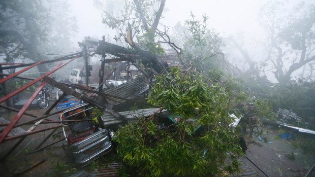 A tricycle is pinned by tree branches at the height of super typhoon Haima that lashes Narvacan township, Philippines.