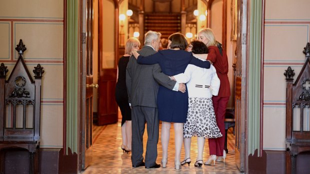 Ms Berejiklian embaces her parents and sisters at Government House.