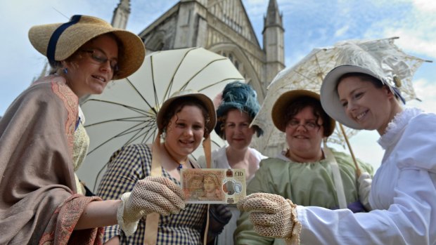 Women in period costume pose with one of the Bank of England's new £10 note, during its unveiling at Winchester Cathedral, July 18, 2017