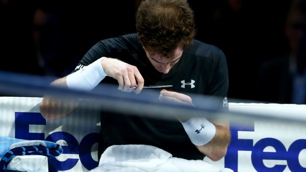 Chop chop: Andy Murray gives his fringe a trim in between games.