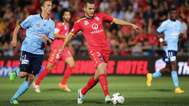 Deft touch: Adelaide United's Nigel Boogaard slides a pass through the Sydney FC defence.