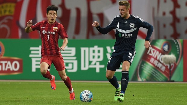 Wu Lei of Shanghai SIPG and Nicholas Ansell of Melbourne Victory tread warily as they approach the ball.