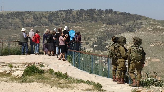 Israeli soldiers stand guard at the occupied West Bank settlement of Mitzpe Yosef as a guide points out Joseph's Tomb to tourists. 