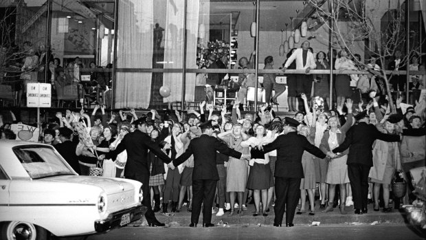 Police officers hold back the tide of fans screaming for the Beatles outside the Sheraton Hotel, where they stayed in Sydney during their 1964 Australian tour.