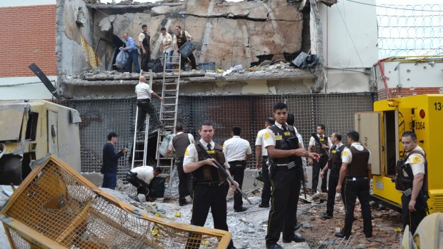 Guards and police inspect the building blown up by the armed gang in the early morning in Ciudad del Este in Paraguay on Tuesday. 