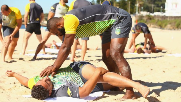 Semi Radradra assists Josh Papalii during stretching at the Australia Kangaroos team recovery session before Friday night's Test.