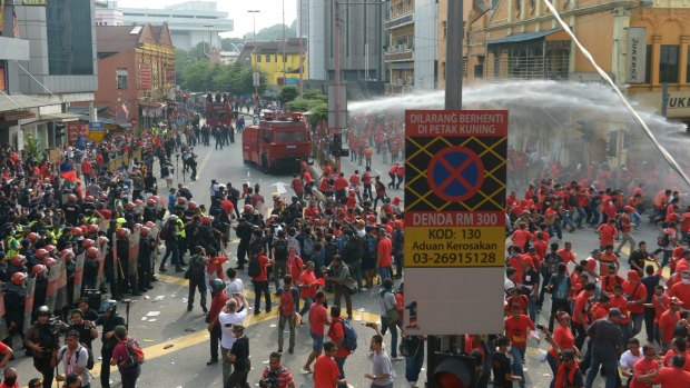 Riot police fire a water cannon at  pro-government "red shirt" protesters as they try to enter Chinatown during a demonstration in Kuala Lumpur on Wednesday. 