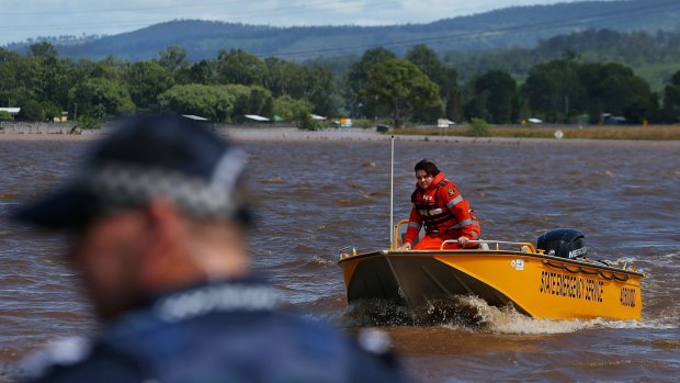 SES workers return to the edge of floodwaters in Beaudesert.