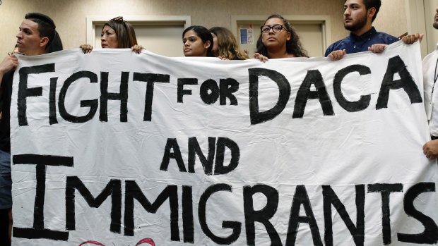 People hold up a banner during an event in Las Vegas to protest against President Donald Trump's decision to revoke the Deferred Action for Childhood Arrivals program.
