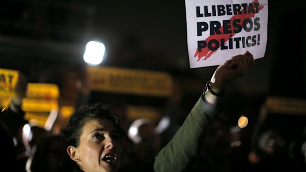 A woman holds a sign in Catalan reading: "Freedom for the political prisoners" outside the Catalonian Parliament in Barcelona on Thursday to protest against the decision of a judge to jail former members of the Catalan government.