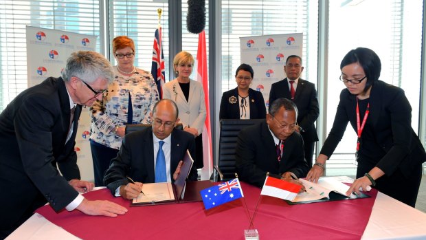 DFAT secretary Peter Varghese (left) signs a Memorandum of Understanding with Indonesian Head of Counter-Terrorism Saut Usman as Indonesian and Australian ministers look on during the third Australia-Indonesia 2+2 meeting on Monday.