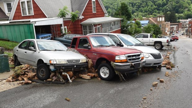Cars and large rocks are smashed together after being carried down Oakford Avenue by flood waters in Richwood, West Virginia.