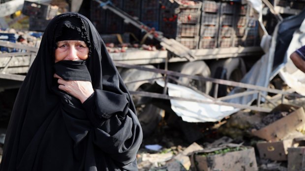 An Iraqi woman grieves at the scene of the bomb attack.