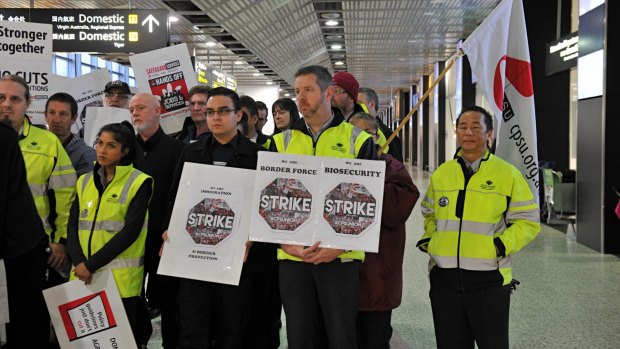 Workers at Melbourne Airport stop work amid an industrial campaign for better pay earlier this year.