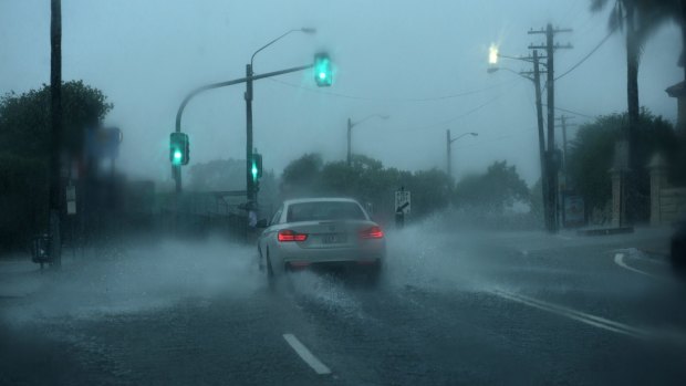 A car drives through flash flooding at Petersham on Tuesday morning.