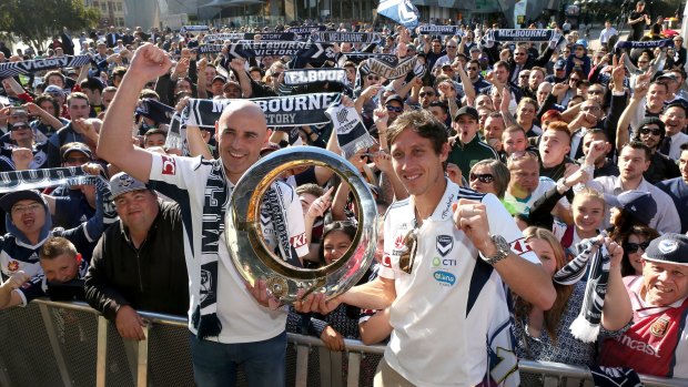 Victory coach Kevin Muscat and captain Mark Milligan with the A-League trophy at Federation Square.