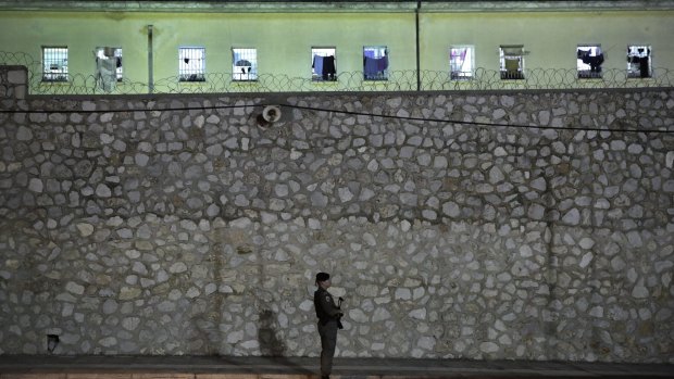 Riot police officers stand guard outside Korydallos Prison.